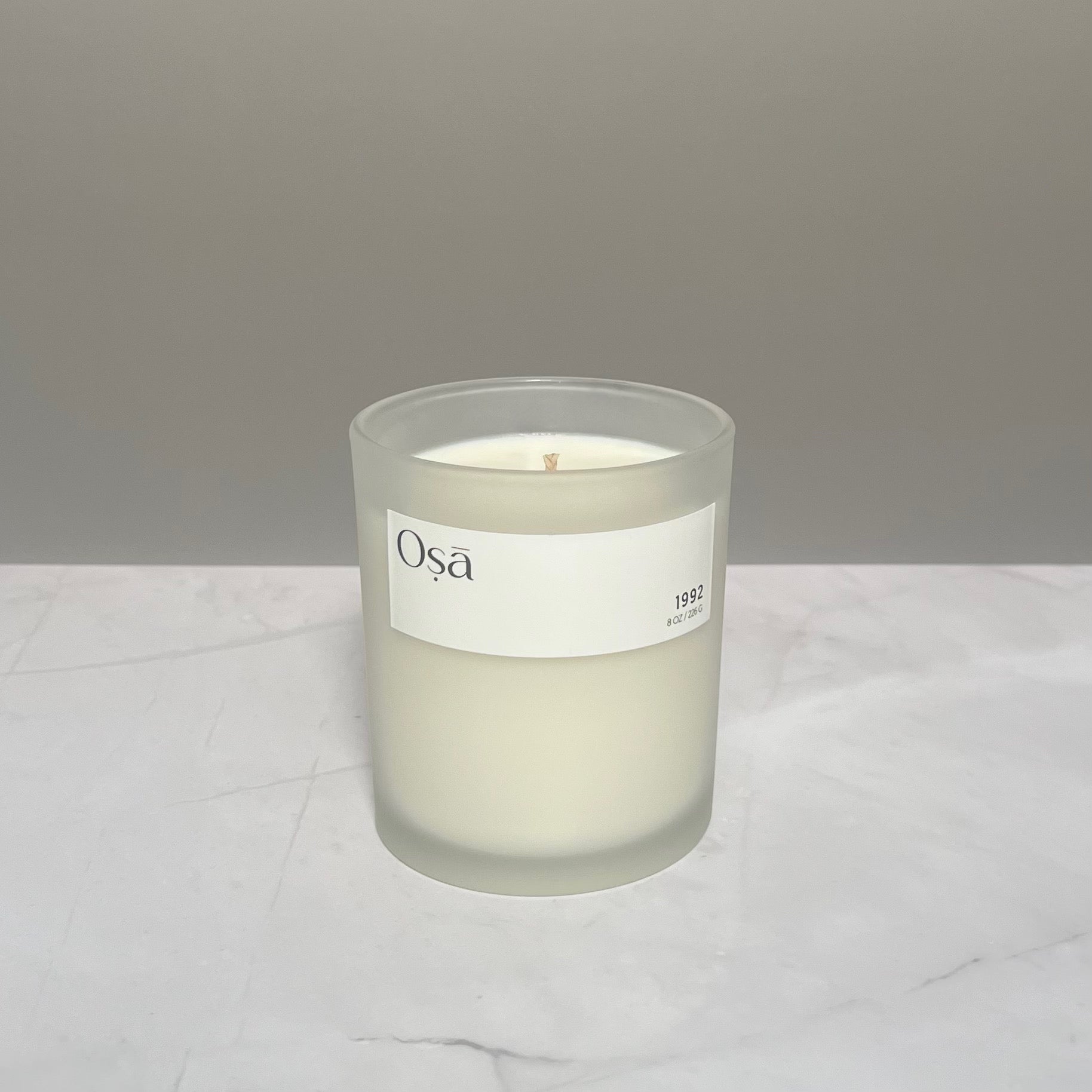 A candle on a countertop with a label displaying Osa 1992.