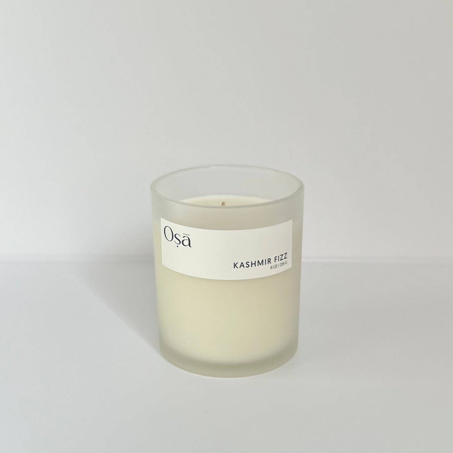 A candle with an Osa Kashmir Fizz label displayed.