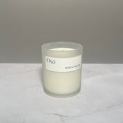 A candle on a countertop with an Osa Mystic Nectar label displayed.