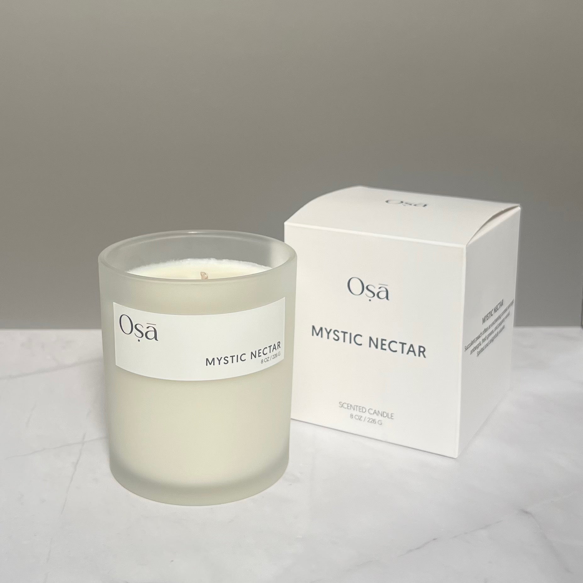 A candle and box with a label displaying Osa Mystic Nectar.